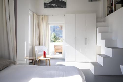 施库尔Chasa Alba的一间卧室配有一张床、一张桌子和一个窗户。