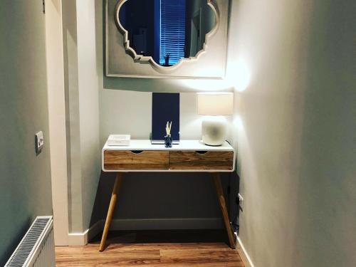 爱丁堡The Lane Apartment的浴室设有一张带台灯和镜子的桌子