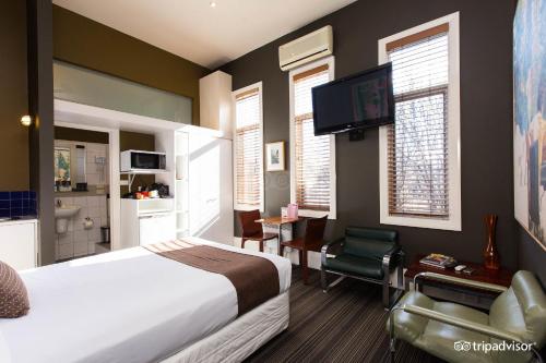 墨尔本Tolarno Hotel - Mirka’s Studio - Australia的一间卧室配有一张床、一张书桌和一台电视。