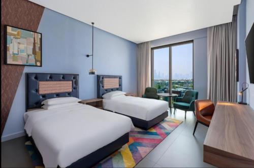 迪拜Hyatt Centric Jumeirah - Dubai Twin Room - UAE的酒店客房配有两张床和一张书桌