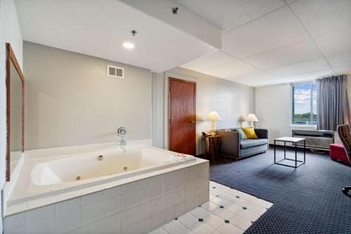 滑铁卢Econo Lodge Inn & Suites的带浴缸的大浴室和客厅。