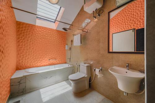 Dod BallāpurThe Venue By Seasons Suites-的橙色浴室设有卫生间和水槽