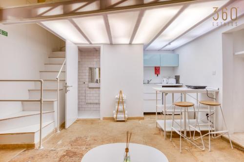 拉巴特Authentic & cosy duplex home in charming Rabat By 360 Estates的一间设有楼梯的房间和一间带白色墙壁的厨房