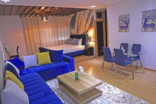 得土安Hotel La Casa Blanca的客厅配有蓝色的沙发和床。