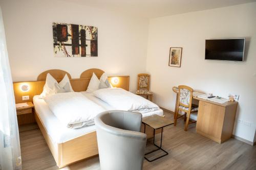 奥拉Garni Meinrad的配有一张床和一张书桌的酒店客房