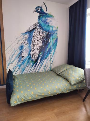 帕比亚尼采STUDIO BLUE BIRD PIĘKNA 2 wejście na kod CENTRUM的墙上一幅孔雀画