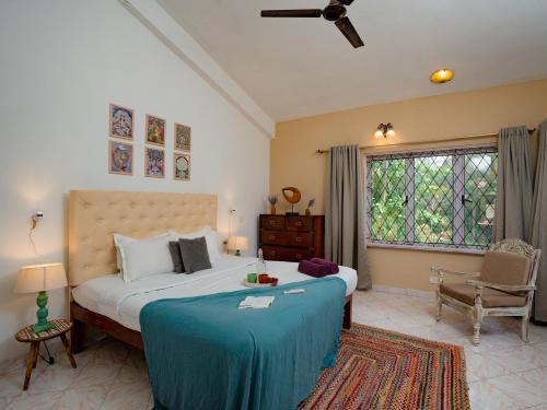 果阿旧城Echo - Classy 3bhk Villa - vagator的一间卧室配有一张带蓝色毯子的大床