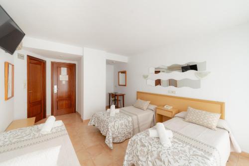 贝尼多姆Hotel Santa Faz的白色的客房配有两张床和电视。