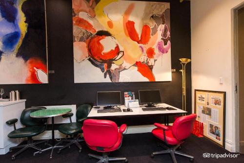 墨尔本Tolarno Hotel - Balazac Room - Australia的一间办公室,配有红色椅子和一张桌子及电脑