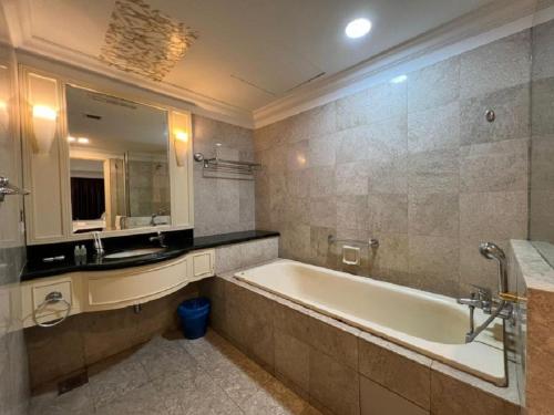 吉隆坡RESORT SUITES AT BARJAYA TIMES SQUARE kL的带浴缸、水槽和镜子的浴室