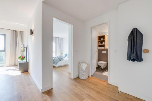 柏林柏林卡尔霍斯特斯马特曼特商务公寓的一间白色客房,配有镜子和一间卧室