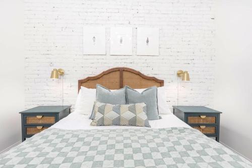 路易斯威尔Decadent Cityscape Retreat的一间卧室配有带枕头的床铺和两张桌子