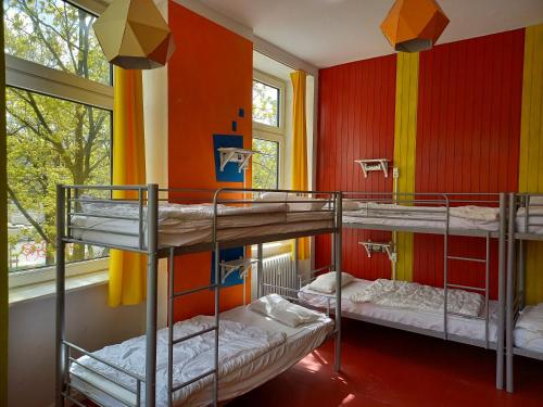 汉堡instantSleep Backpackerhostel St Pauli的带三张双层床的客房,拥有色彩缤纷的墙壁