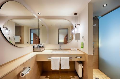 达姆施塔特Welcome Hotel Darmstadt City Center的一间带水槽和镜子的浴室