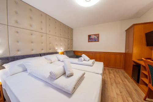 佩奇Szinbád Hotel的一间卧室配有两张带白色枕头的床