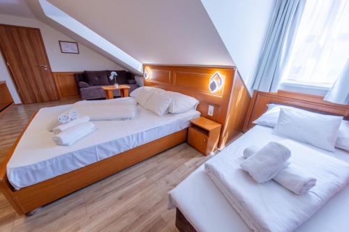 佩奇Szinbád Hotel的一间卧室配有两张床和白色毛巾。