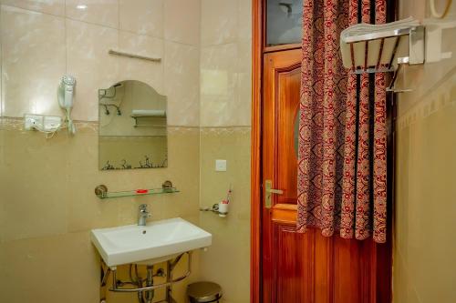 鲁亨盖里Home Inn Hotel Rwanda的一间带水槽和红色门的浴室