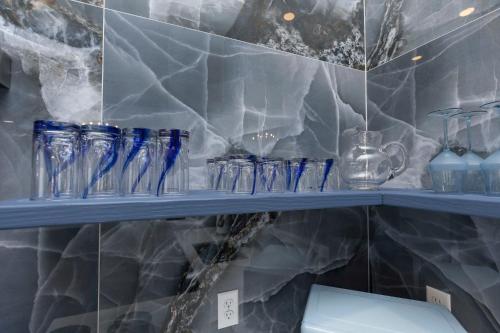 路易斯威尔Lavish Blue Suite 5 with Hollyhock的上面有蓝色玻璃物品的架子
