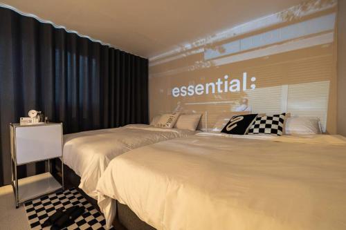 首尔Luxury Songpa Room的客房内的两张床,上面标有基本的标志