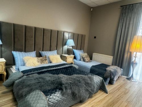 罗兹省康斯坦丁努夫Apartamenty i pokoje „Pod Jedynką”的一间带两张床和大床头的卧室