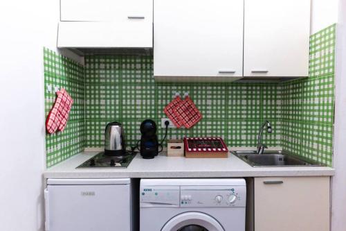 莱切Davids Room Palazzo Tamborino的绿色瓷砖厨房配有洗衣机和水槽
