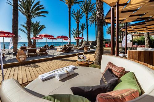 普拉亚登博萨Hotel Vibra Algarb的海滩上种有棕榈树和椅子的度假胜地
