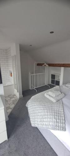 卡迪夫3 Bed Home in Heart of Cardiff的一间白色的卧室,配有床和楼梯