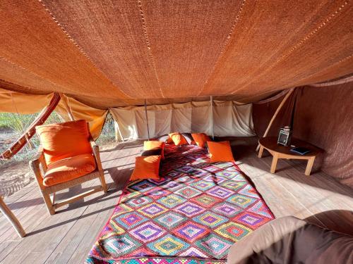 DouaïraLe Khaïma Bio, Oasis écologique au bord de l'océan的帐篷内的一张床和一把椅子