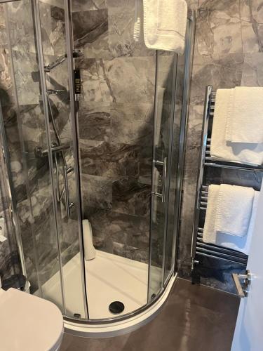 基尔肯尼格兰笛尼酒店的带淋浴、卫生间和毛巾的浴室