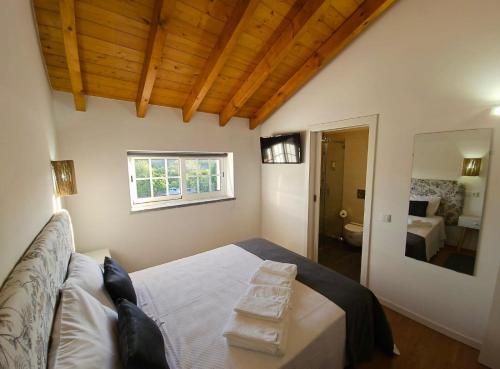 塞卡尔Casa do Chafariz - Rooms的一间带大床的卧室和一间浴室