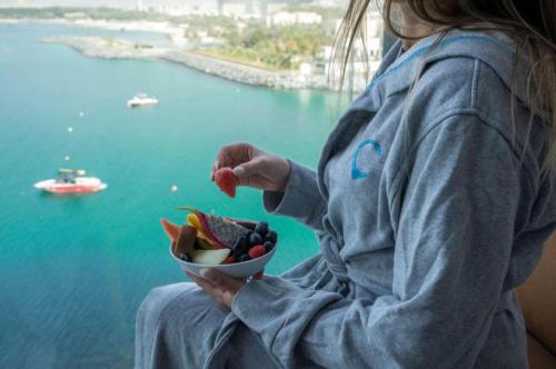 迪拜Hyatt Centric Jumeirah - Twin Room Sea View - UAE的一边欣赏水面,一边吃水果