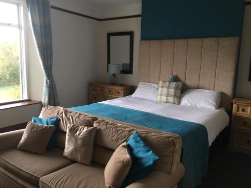 ManatonKestor Inn, Manaton, Dartmoor National Park, Newton Abbot, Devon的一间卧室配有一张大床和一张沙发