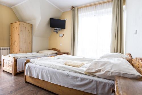 扎科帕内Willa Sport的卧室设有两张床,墙上配有电视。
