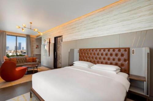 迪拜Hyatt Centric Jumeirah Dubai - Deluxe Room - UAE的卧室配有一张白色的大床和一张沙发。