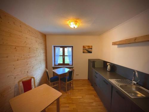 基姆湖畔贝尔瑙Ferienhaus Daxenberger的厨房配有桌子、水槽和桌椅