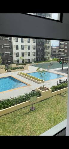 伊洛伊洛AVIDA ATRIA TOWER 3 Unit 3-320的享有庭院的景色,在一座建筑中设有两个游泳池