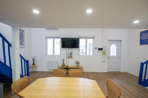 里昂Casa Azul - Belle maisonnette colorée - Garibaldi的配有桌椅和电视的客房