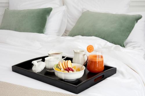 伦敦2 Chesham Hotel的床上装有食物和饮料的托盘