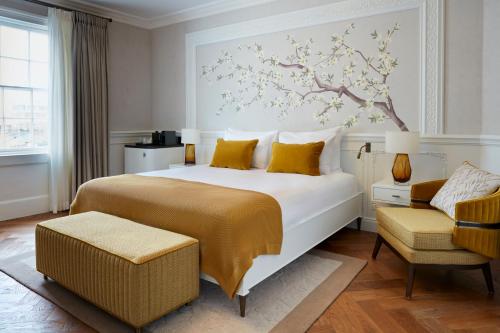 伦敦2 Chesham Hotel的卧室配有一张大床,墙上挂着一幅树壁画