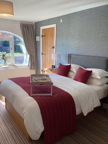 比代尔The Garden rooms的酒店客房配有一张带红色枕头的大床