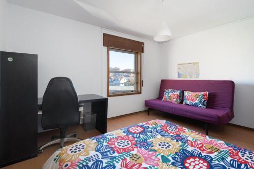 波尔图Vale Formoso Guest House的一间卧室配有一张床和一张紫色沙发