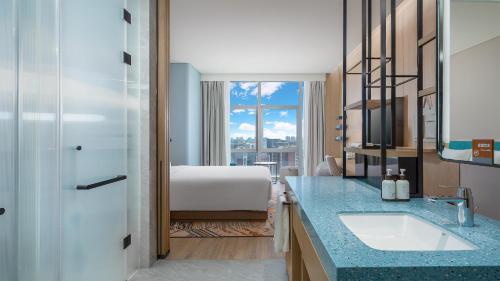 银川银川阅海逸衡酒店的一间带水槽的浴室和一张位于客房内的床