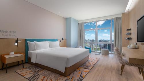 银川银川阅海逸衡酒店的卧室配有一张白色大床和一张书桌