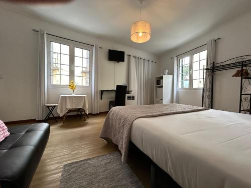丰沙尔Palmar Rooms的卧室配有床、桌子和窗户。