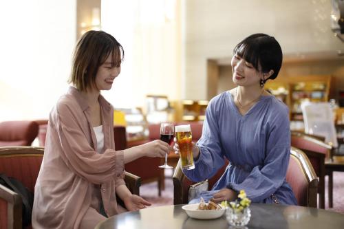 神户有馬 瑞宝園的两个女人坐在桌子边,喝杯酒