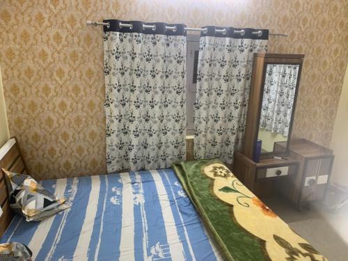 巴特那Sukh garden luxury stay的一间卧室配有床、镜子和窗帘