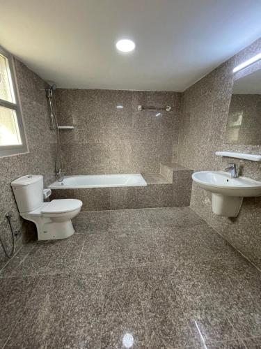 麦纳麦Flamingo Cottages的带浴缸、卫生间和盥洗盆的浴室