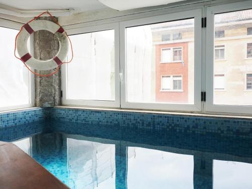的里雅斯特达乐拉住宿加早餐旅馆的一个带镜子和窗户的游泳池