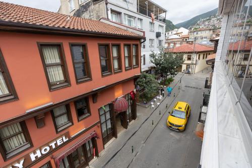 伯萨BURSA GRAND FAMİLY HOTEL & SpA的停在大楼旁的街道上的黄色汽车