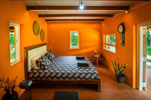MakanduraChimney House by Serendia的一间卧室拥有橙色的墙壁,里面设有一张床